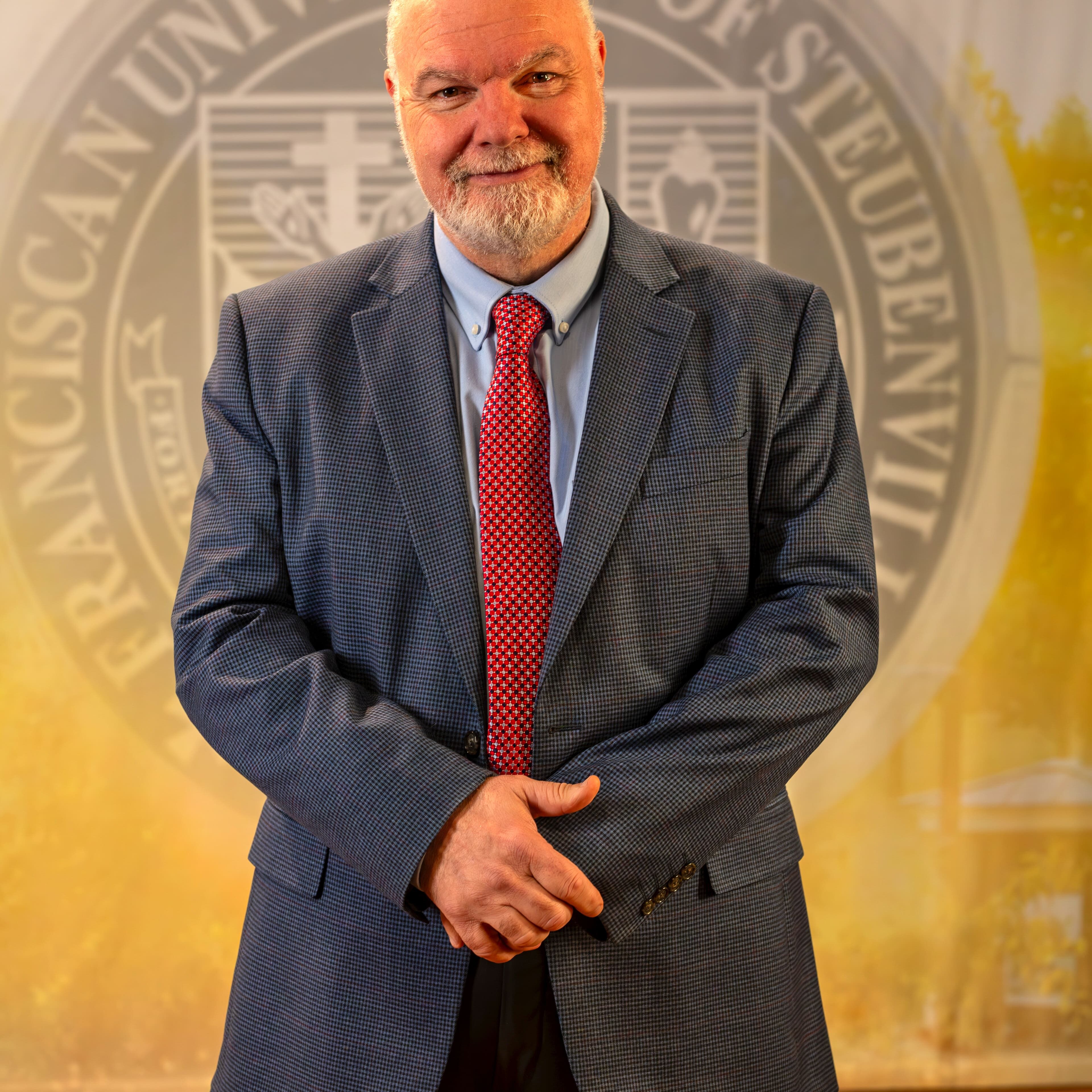 To Web – Dr. Petroc Willey FEB2025 –6 Dr. Petroc Willey standing in front of a university seal.